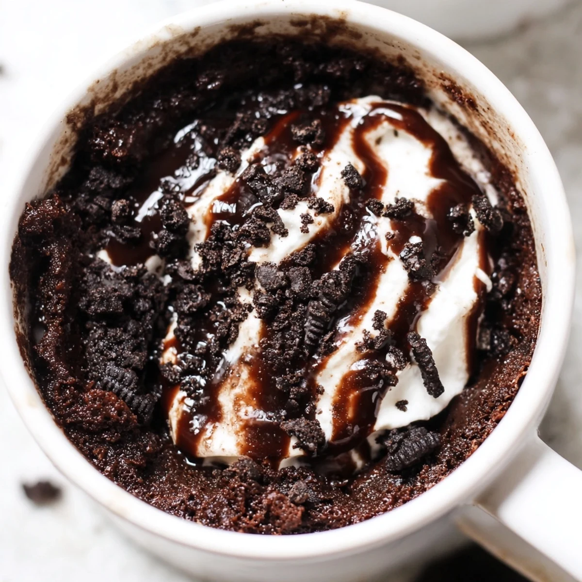 This warm, delicious Oreo mug cake shows a quick and easy microwave dessert with whipped cream.