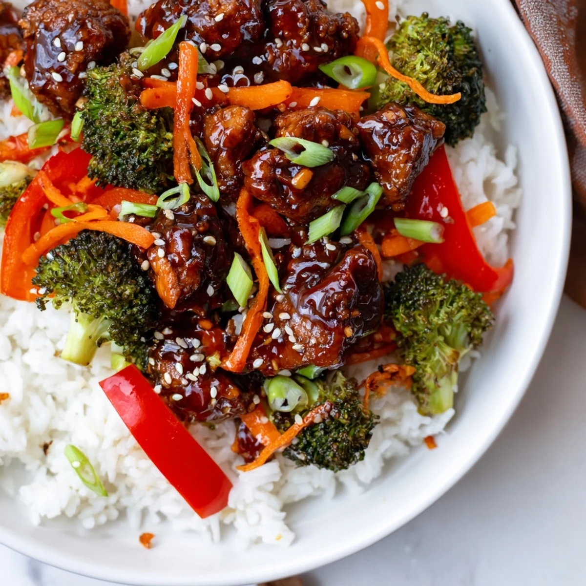 Tender teriyaki chicken served over fluffy rice, garnished with sesame seeds; a delicious, balanced meal.