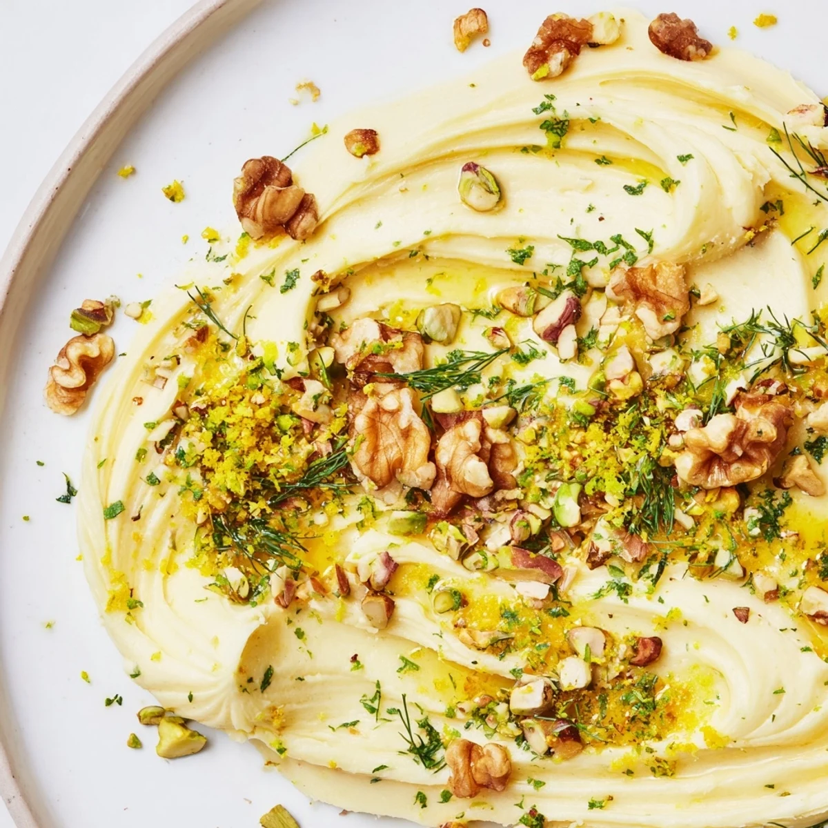 Vibrant photo of a stunning butter board charcuterie artfully decorated with lemon zest and flaky sea salt.