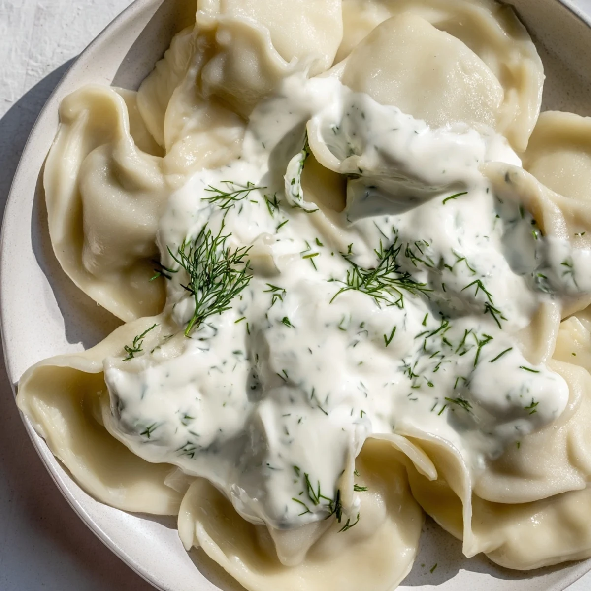 Steaming hot Russian pelmeni, savory meat-filled dumplings, ready to be enjoyed with sour cream.