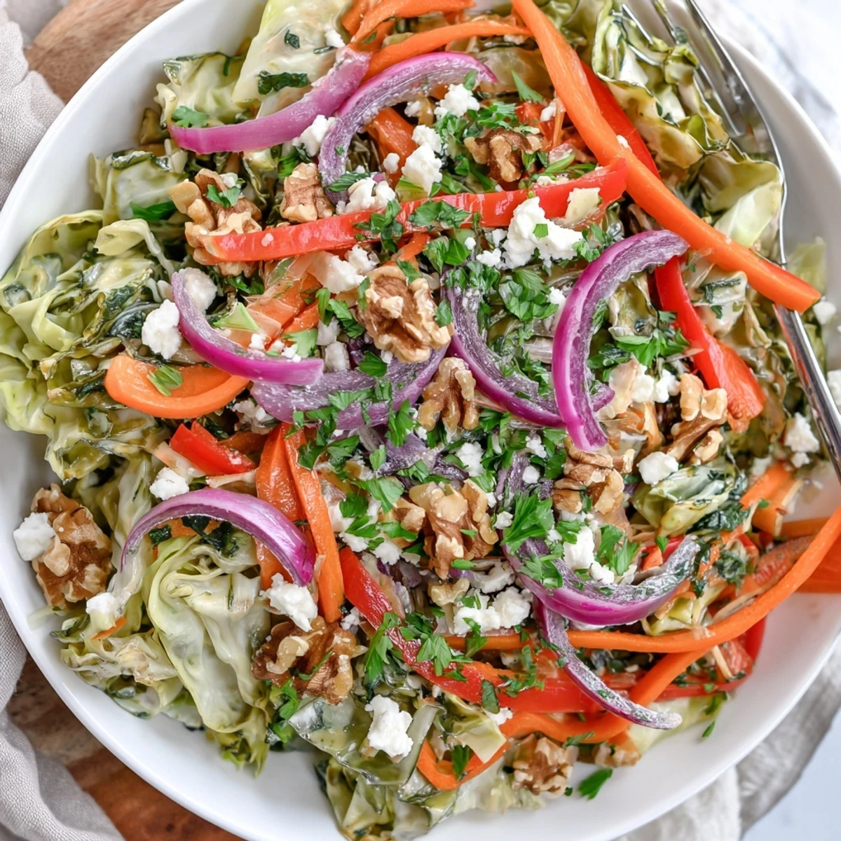 A vibrant bowl of Cooked and Loved Cabbage Salad with sautéed cabbage, crisp carrots, and fresh parsley tossed in a tangy dressing.