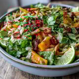 Golden ripe mangoes and colorful vegetables in the Refreshing Mango Salad with Lime Dressing are tossed with a zesty lime-honey dressing and garnished with cilantro, ready for a light lunch or dinner.  
