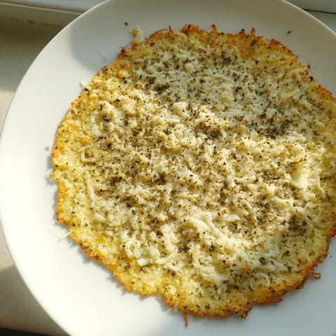 A close-up of a freshly baked Cauliflower Pizza Crust, revealing its delicious, textured surface.