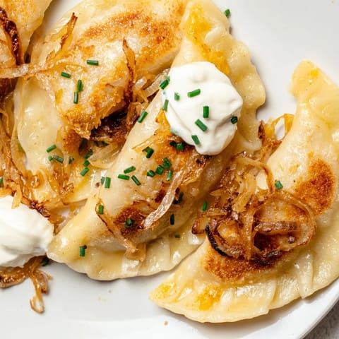 A close-up shot of perfectly pan-fried Polish pierogi, showcasing the delicious potato and cheese filling.
