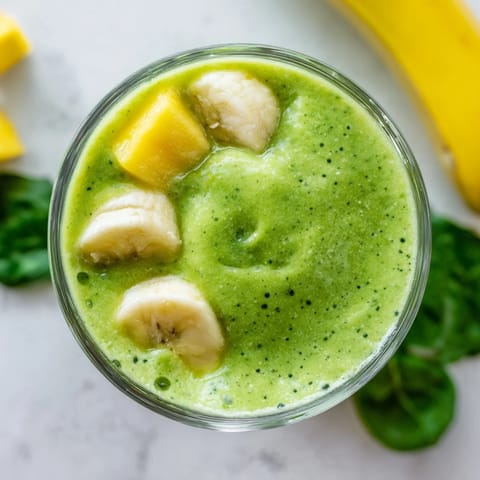 Creamy spinach-hidden smoothie served in a mason jar with a straw, perfect for a healthy breakfast.